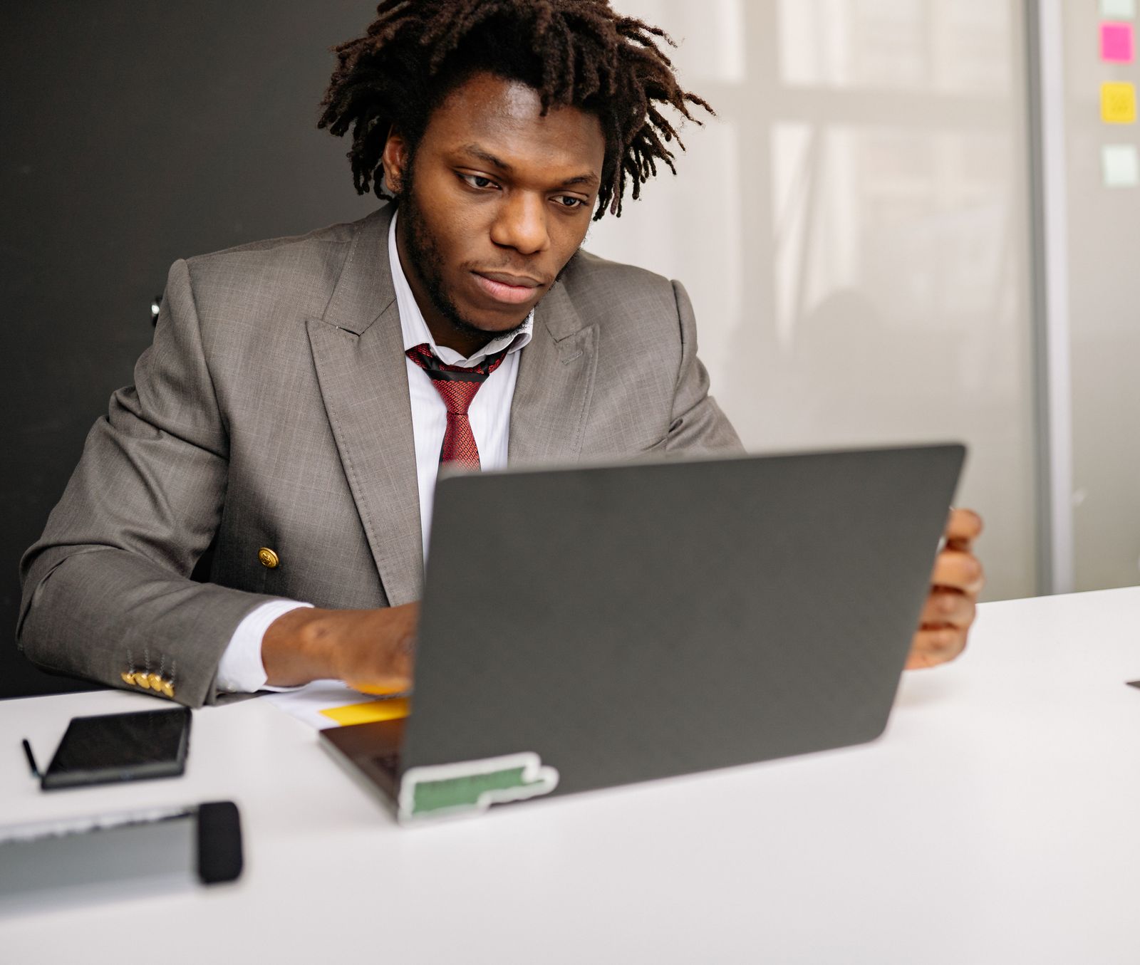 Black software professional working on a laptop in a modern office