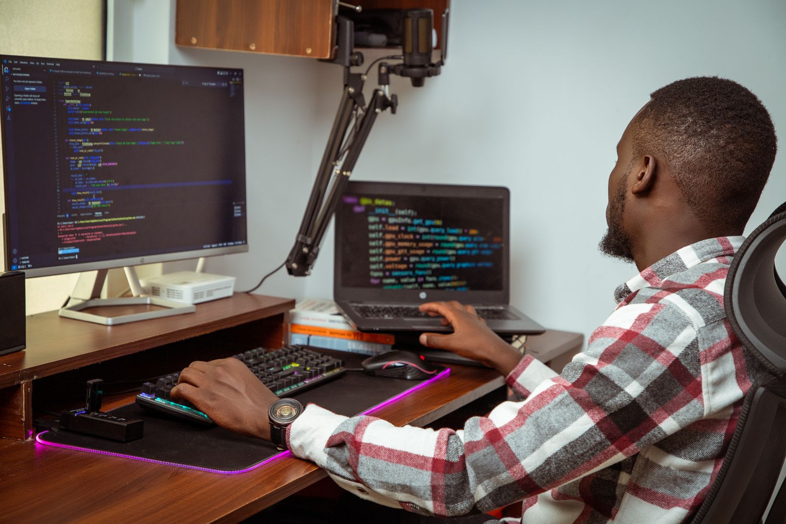 African web developer coding on multiple screens in Kenya
